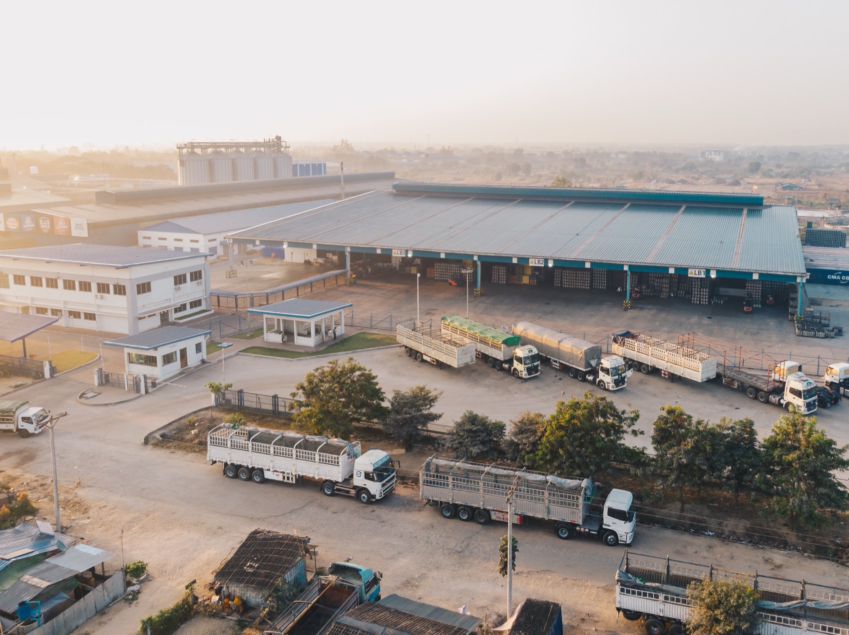 A distribution yard seen from above, with loading bays and trucks lined up alongside.