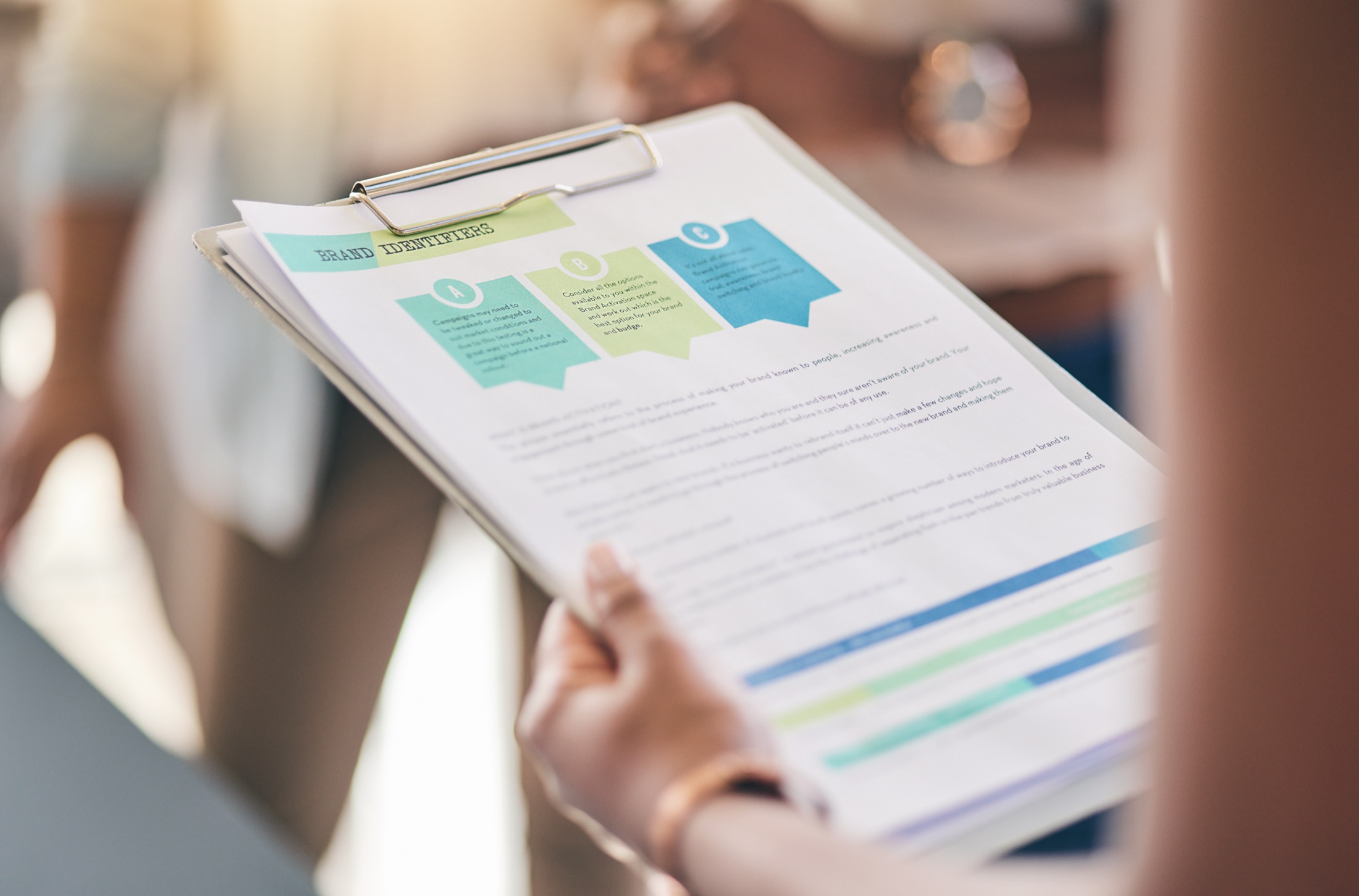 A printed specification document being read on a clipboard.